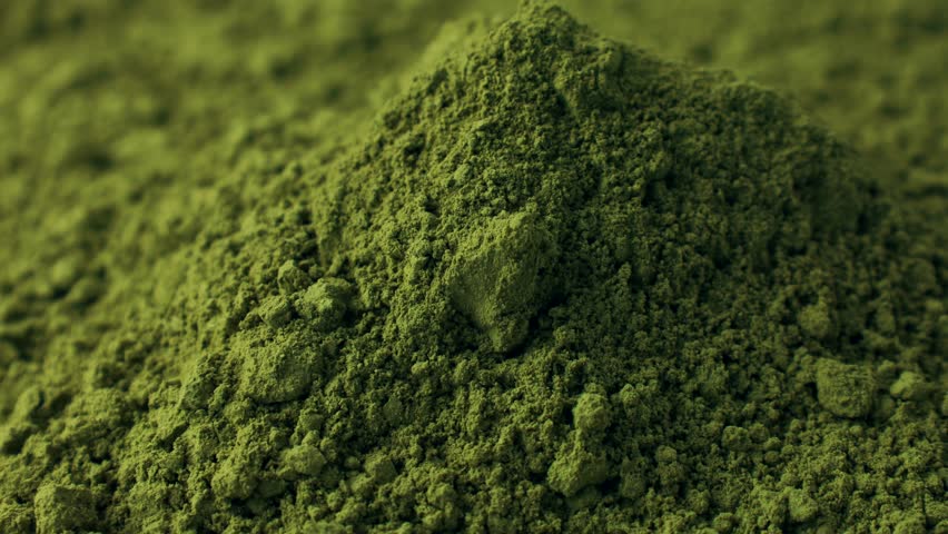Matcha green tea powder falling down close up. Moringa, Spirulina, chlorella superfoods