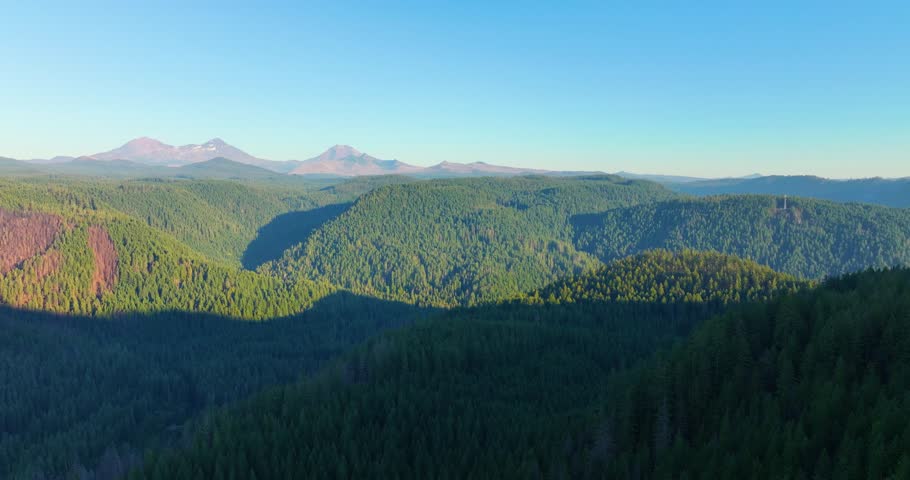 Drone footage of the Three Sisters volcanic peaks with golden light over Oregon
