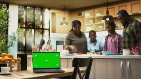 Mockup display black family enjoying pizza day in kitchen with laptop, laughing as they cook a homemade meal. Domestic activity shows joy and the warmth of family bonding. Camera A. - Powered by Shutterstock - Get 15% off with code: PIKWIZARD15