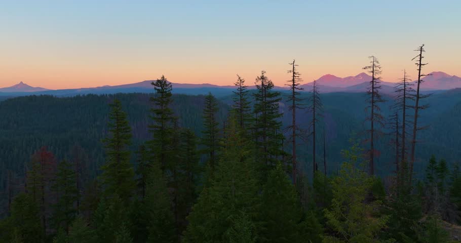 Aerial drone footage of Oregon’s volcanic peaks glowing under sunset skies