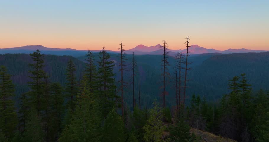 Drone footage flying over Oregon wilderness toward the Three Sisters mountains