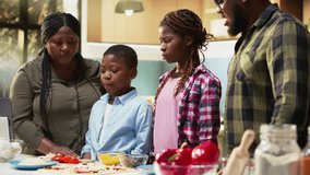 Smiling children help parents prepare pizza by sprinkling grated cheese in the kitchen, family cooking activity during the weekend. Cozy moment of teamwork and meal preparation. Camera B. - Powered by Shutterstock - Get 15% off with code: PIKWIZARD15