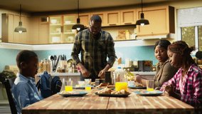Father packing school lunch for his young son and preparing his backpack, family members enjoying breakfast together during cozy morning in the kitchen. Meal prep school bag. Camera A. - Powered by Shutterstock - Get 15% off with code: PIKWIZARD15