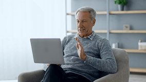 Senior man enjoying virtual connection while sitting in cozy living room space - Powered by Shutterstock - Get 15% off with code: PIKWIZARD15