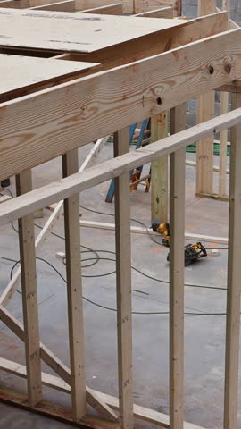 Wooden beams rafters are being installed on house frame new construction work.