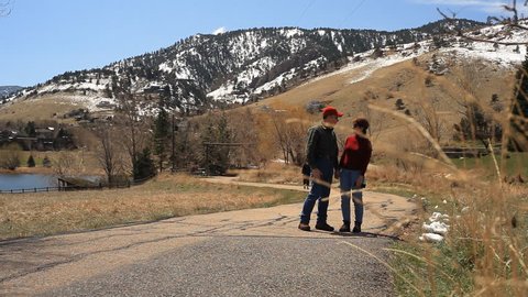 A man and a woman walking on a recreational trail in the foothills near Boulder Colorado.