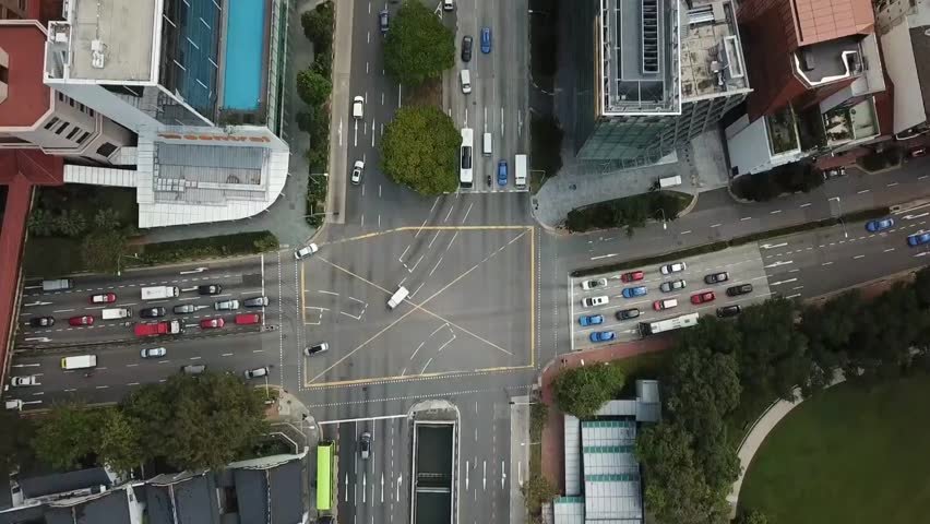Aerial view of modern city with skyscrapers, roads, and surrounding buildings in daylight.