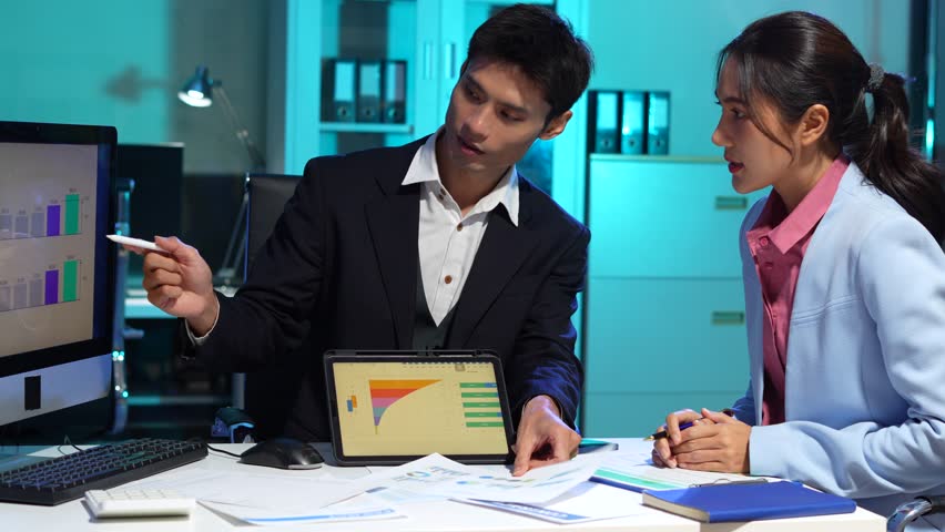 Businessmen team or financial data analysts working overtime with tablets and laptop computers and data graphs together. Plan to analyzing projects in the office.