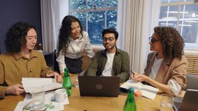 Diverse group of coworkers collaborating in modern office standing and sitting around conference table discussing business ideas showing teamwork communication and creative corporate culture - Powered by Shutterstock - Get 15% off with code: PIKWIZARD15