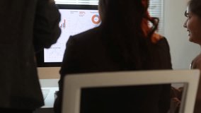 Business team discussing financial data displayed on computer screen. Businesswoman is working while colleagues contribute to the analysis. - Powered by Shutterstock - Get 15% off with code: PIKWIZARD15