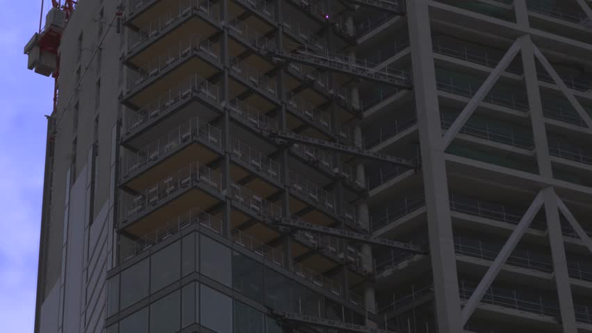 Pan Up of Tall Skyscraper with Cranes High Above Constructing New Building for Offices in London, UK.