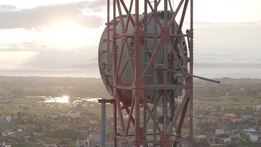 An aerial shot in Log format of Peregrine falcon perch at a cellular tower in a morning time in Bali