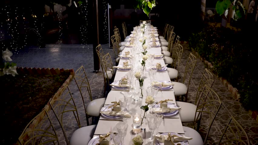 Long table is set with stylish decorations and candles, creating a warm atmosphere for a special gathering under the stars. Ideal for celebrations or intimate dinners.