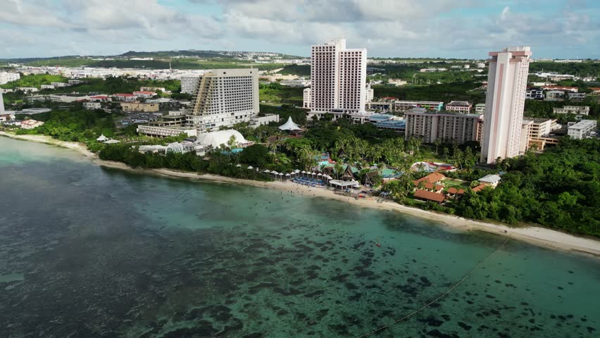 Picturesque aerial drone shot of Pacific Islands Club Hotel Resort and idyllic beach coastline with turquoise waters at Guam, USA