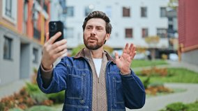 Man outdoors engaging in lively video call using smartphone. Expresses happiness, connection, and joy. Active conversation in urban setting. - Powered by Shutterstock - Get 15% off with code: PIKWIZARD15