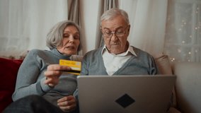 Old man and his wife ordering Christmas gifts online, inputting credit card data . Aged people shopping online in web-store, purchasing utility bills online, cozy Christmas decoration in apartment - Powered by Shutterstock - Get 15% off with code: PIKWIZARD15