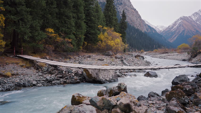Wooden Suspension Bridge over Mountain River