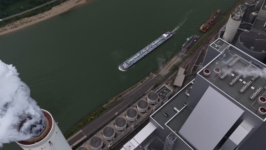 Large scale power plant in Mannheim, Smoking chimney, smoke stack. Aerial close up video of industrial estate at daytime.