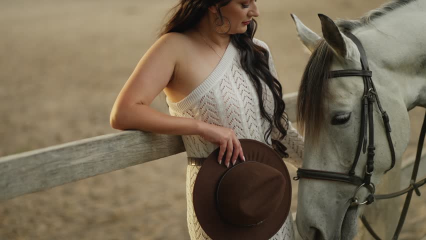Woman in a revealing dress on a ranch near a horse. Concept of a beautiful horsewoman.
