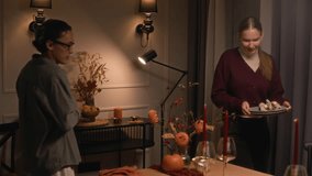 Medium long shot of diverse young couple setting table decorated with autumn ornaments and pumpkins for Thanksgiving celebration - Powered by Shutterstock - Get 15% off with code: PIKWIZARD15