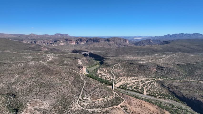 Aerial view of Burro creek bridge cutting across the landscape, a river carving its path through arid terrain, Wikieup, Arizona, United States.