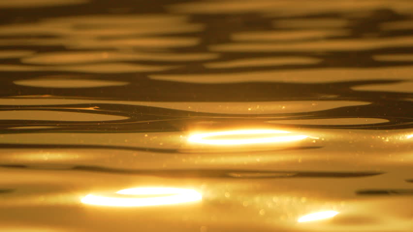 Water golden ripples, abstract shimmering surface with tranquil reflections.