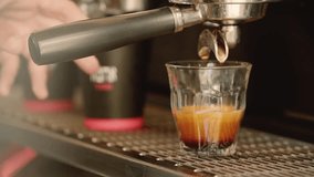 Slow-motion close-up of a barista’s hand picking up a glass of espresso from a coffee machine - Powered by Shutterstock - Get 15% off with code: PIKWIZARD15