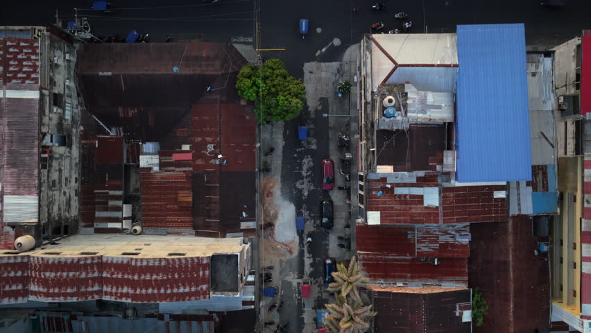 Top down aerial view of traffic with cars, motorcycles, and tuk tuks driving through the streets of Iquitos, largest city in Peruvian Amazon