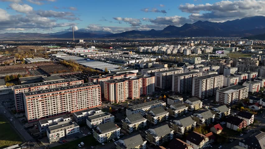 Establishing shot of Coresi Brasov, Romania cityscape with buildings and mountains in the distance