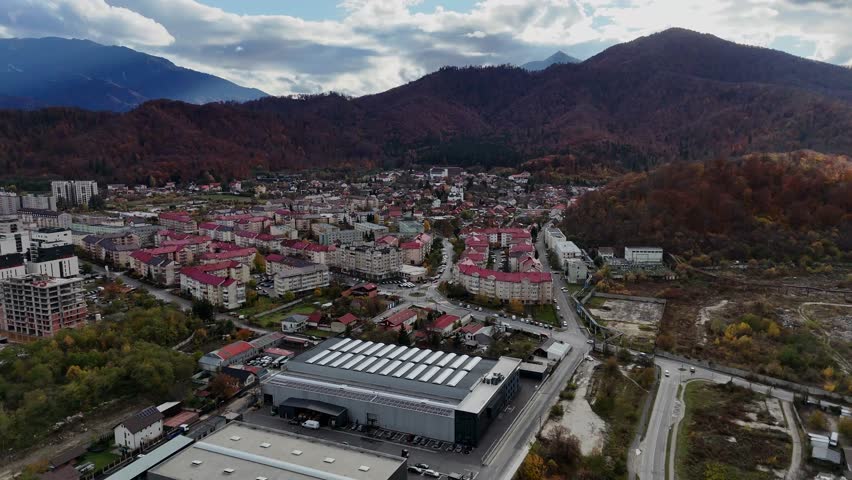 Aerial establishing shot of Brasov Noua, Romania, nestled amid mountains in autumn