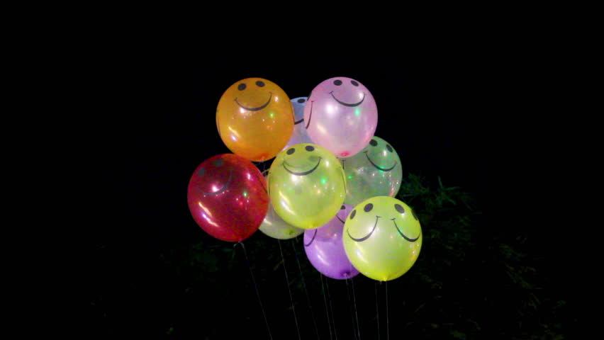 Smiley face balloons glowing beautifully at night representing happiness, fun, and celebration atmosphere, perfect for themes of positivity, joy, and party decoration.