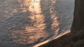 Ocean Waves Sunset, Golden reflections on tranquil sea water near rugged coastal cliffs and a small beach. - Powered by Shutterstock - Get 15% off with code: PIKWIZARD15