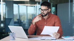 Busy thoughtful businessman analyzing financial documents checking data on laptop while sitting at desk at workplace in a business office. Financier deals with financial reports, engaged in accounting - Powered by Shutterstock - Get 15% off with code: PIKWIZARD15