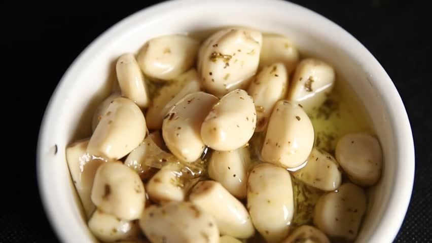 Garlic slices in flavored oil roasted garlic slice in oil fast food natural tasty appetizer fresh delicious gourmet food background on the table rustic top view copy space vegetarian or vegan food