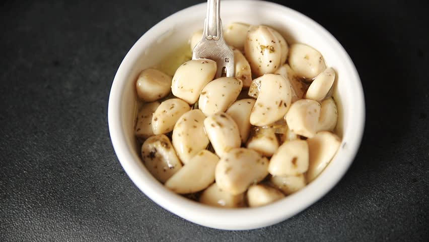 Garlic slices in flavored oil roasted garlic slice in oil fast food natural tasty appetizer fresh delicious gourmet food background on the table rustic top view copy space vegetarian or vegan food