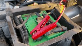 red jumper cable clamp connected to car battery terminal. Ideal for automotive repair, battery charging, power, and emergency or safety tutorial videos. - Powered by Shutterstock - Get 15% off with code: PIKWIZARD15