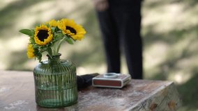 bright yellow sunflowers in green ribbed vase catching sunlight on outdoor table - Powered by Shutterstock - Get 15% off with code: PIKWIZARD15