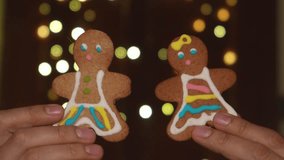 Two gingerbread cookies shaped like a couple held by hands with glowing bokeh lights in the background. Christmas love. - Powered by Shutterstock - Get 15% off with code: PIKWIZARD15