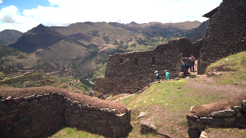 Sacred Valley, Peru - 10 19 2025: Tourists explore ancient Pisac Archaeological Park with historical Inca stone architecture, agricultural terraces, stunning, windy Andean landscape under blue skies