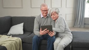 Senior old couple with tablet watching video online. Husband wife spending time together at home. Happy modern mature senior couple using tablet for family entertainment. Old people modern technology - Powered by Shutterstock - Get 15% off with code: PIKWIZARD15