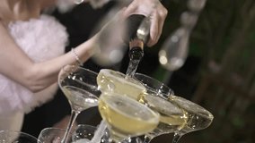 A beautifully lit moment where a couple pours sparkling wine into the top glass of a tiered tower. - Powered by Shutterstock - Get 15% off with code: PIKWIZARD15