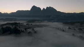 Cinematic aerial view of Sassolungo massif rising above a sea of clouds at sunrise, serene Alpe di Siusi alpine landscape in the Dolomites, Italian Alps travel destination - Powered by Shutterstock - Get 15% off with code: PIKWIZARD15