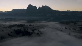 Cinematic aerial view of Sassolungo massif rising above a sea of clouds at sunrise, serene Alpe di Siusi alpine landscape in the Dolomites, Italian Alps travel destination - Powered by Shutterstock - Get 15% off with code: PIKWIZARD15
