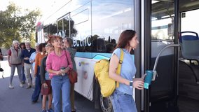 Diverse crowd of passengers lining up and getting on a modern electric bus at a city stop. Public transport promoting sustainable mobility - Powered by Shutterstock - Get 15% off with code: PIKWIZARD15