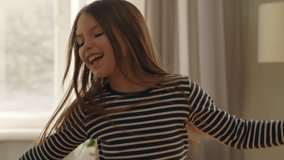 Happy Caucasian little girl offspring daughter kid child dancing spinning rotating at home smiling dance flying long hair having fun indoors enjoying music positive moving childhood playful relax - Powered by Shutterstock - Get 15% off with code: PIKWIZARD15