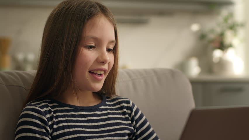 Caucasian little girl child kid schoolgirl daughter using laptop pc computer at home smiling positive cheerful typing internet application distant educate study communication online carefree browsing - Powered by Shutterstock - Get 15% off with code: PIKWIZARD15