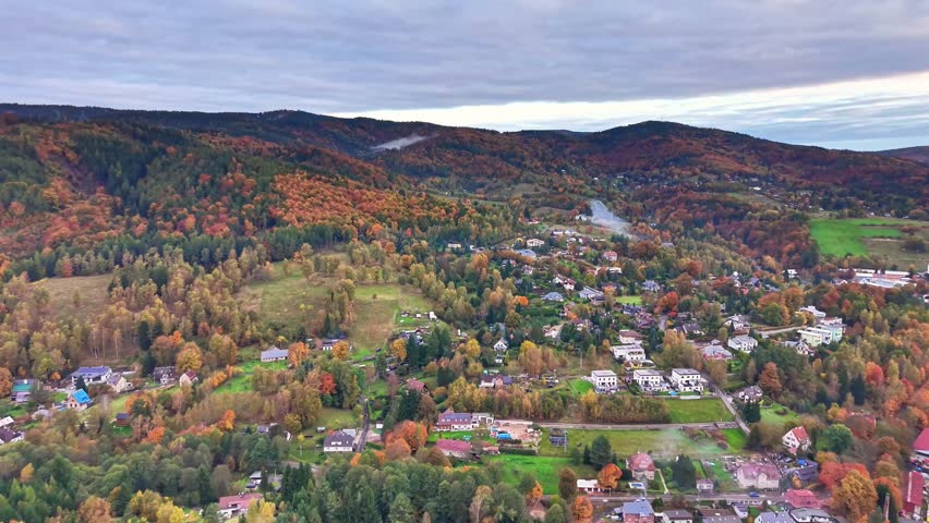 hilltop autumn community, serene mountain settlement with vibrant foliage and charming streets