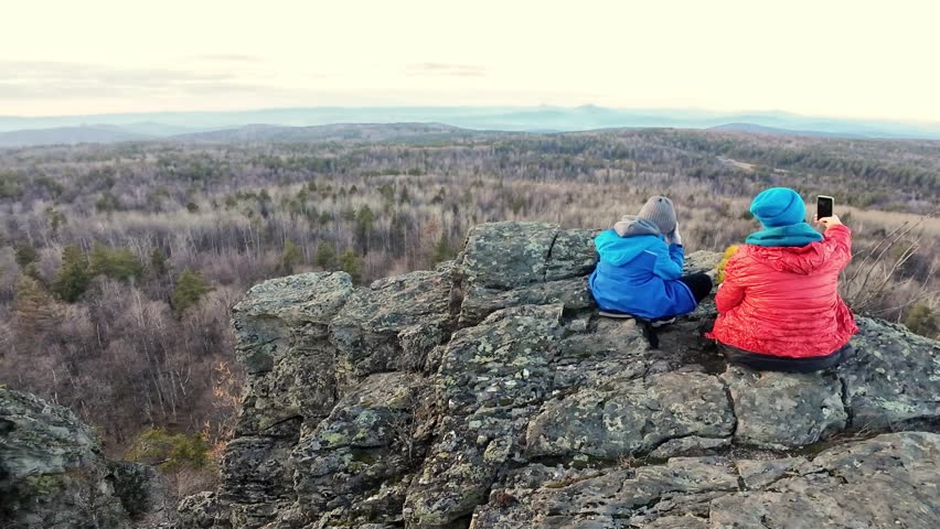 Group capturing scenic daylight view, Companions photographing expansive landscape as daylight fades softly, Group of friends taking pictures of breathtaking scenery at dusk from mountain