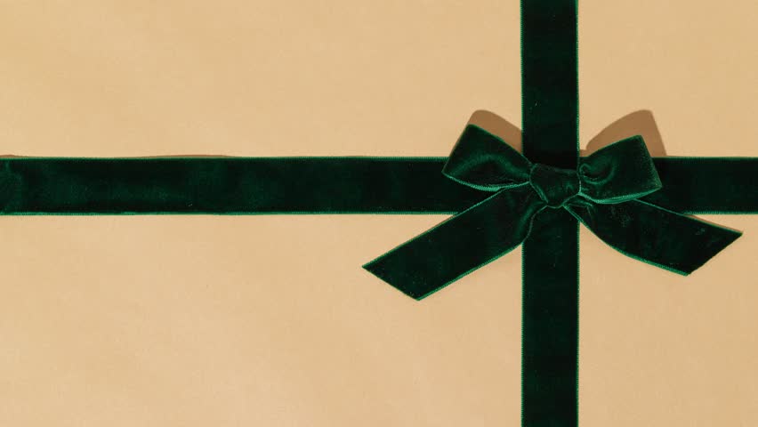 Unwrapping gift revealing a green screen - Stop Motion Animation - Green velvet bow on Christmas wrapping paper