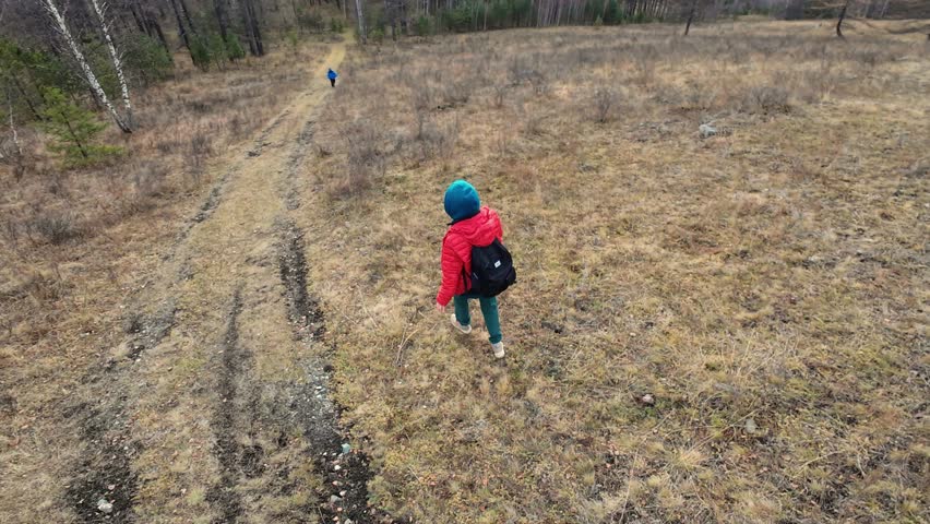 Drone captures hiker, Young adventurer in marshland viewed from above, Overhead shot of crossing hiker in wet terrain, Aerial view of individual navigating through expansive marshy area